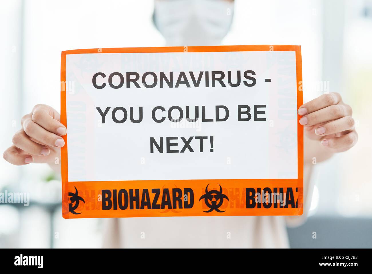 Con amore e consapevolezza, sconfiggeremo il Coronavirus. Colpo di una donna che tiene in su un segno che dice CORONAVIRUS - POTRESTE ESSERE SEGUENTE. Foto Stock