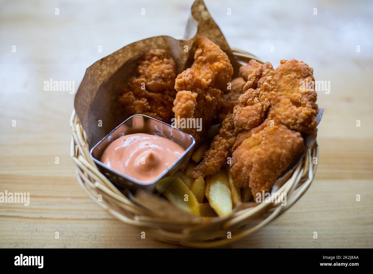 Ali di pollo in un cestino, con patatine fritte e salsa Foto Stock