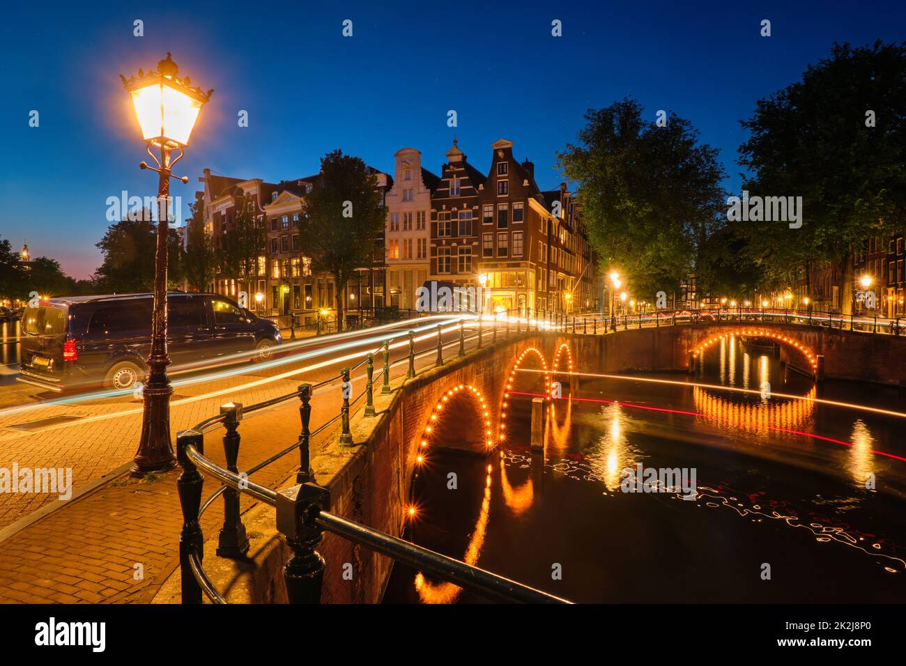 Il canale di Amsterdam, il ponte e le case medievali in serata Foto Stock