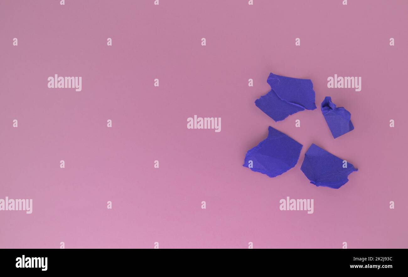 Un mazzo di palline di carta viola stropicciata su sfondo rosa. Il concetto di minimalismo, una copia dello spazio a sinistra Foto Stock