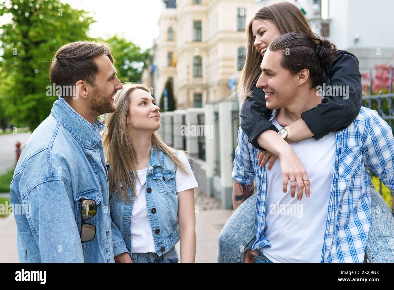 I gruppi di migliori amici si divertono mentre camminano per strada cittadina Foto Stock