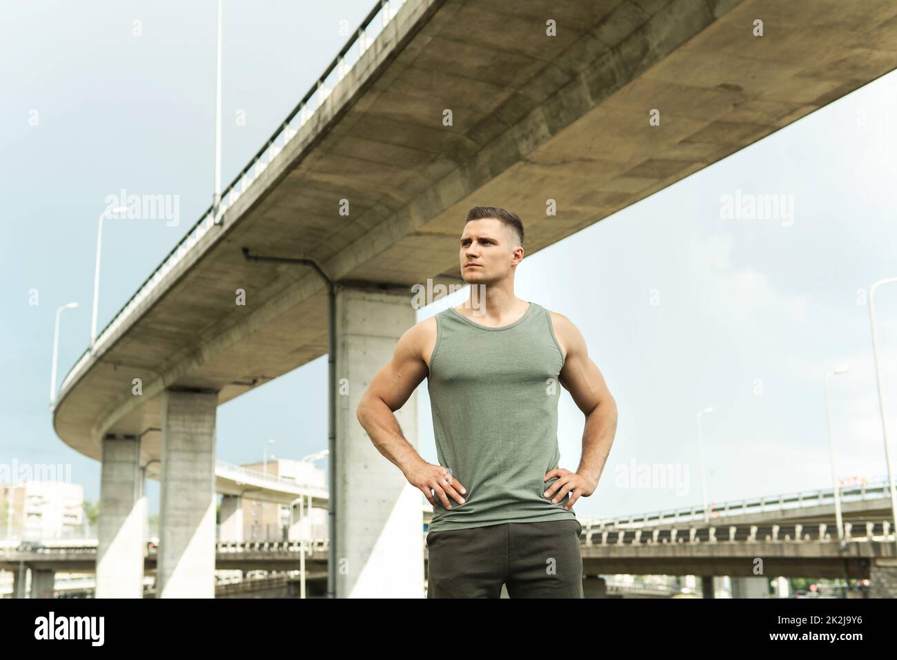 Giovane atletico che indossa abbigliamento sportivo cachi dopo il suo allenamento di strada Foto Stock