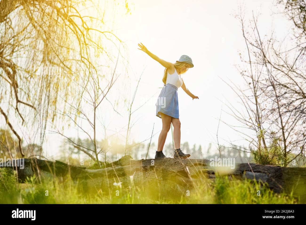 Rinnovato con la fresca vitalità e lo spirito della natura. Scatto di una giovane donna su un ceppo di albero fuori nella campagna. Foto Stock