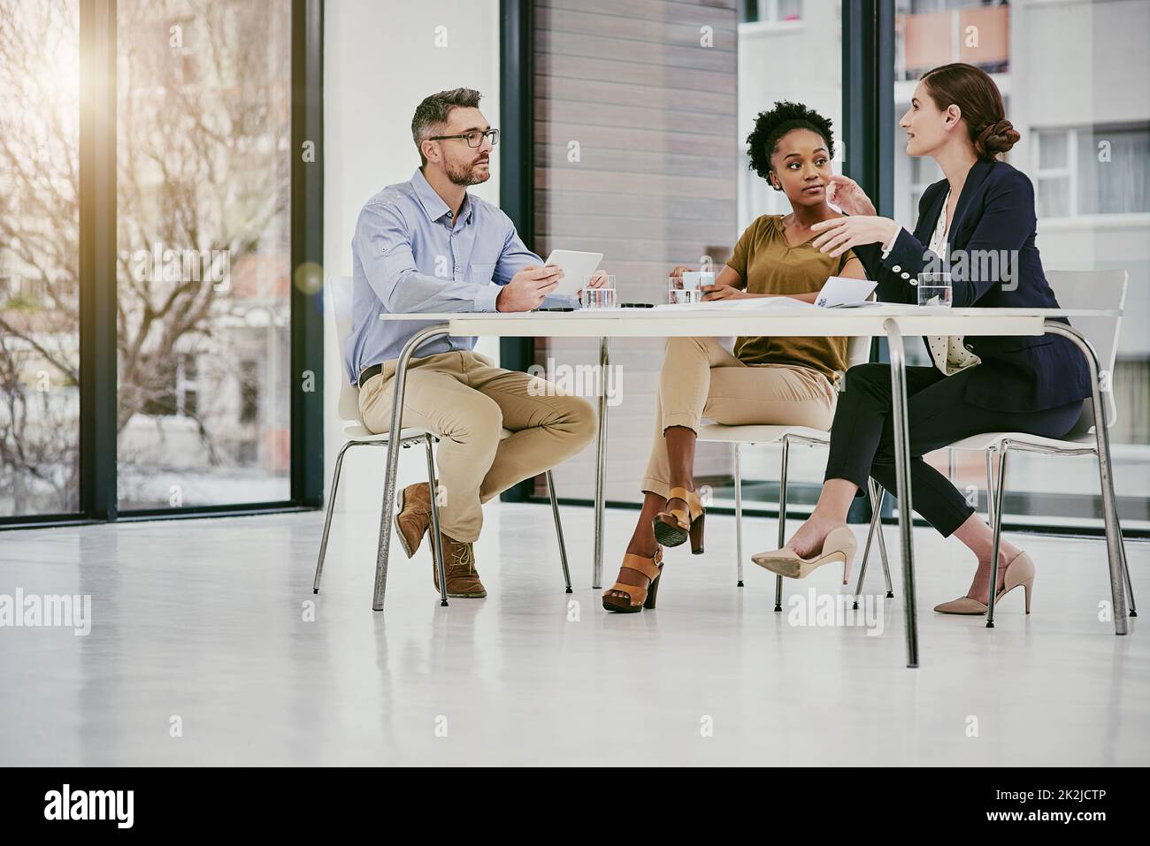 Unire lo sforzo imprenditoriale per il successo aziendale. Foto di un gruppo di colleghi che hanno una riunione in un ufficio moderno. Foto Stock