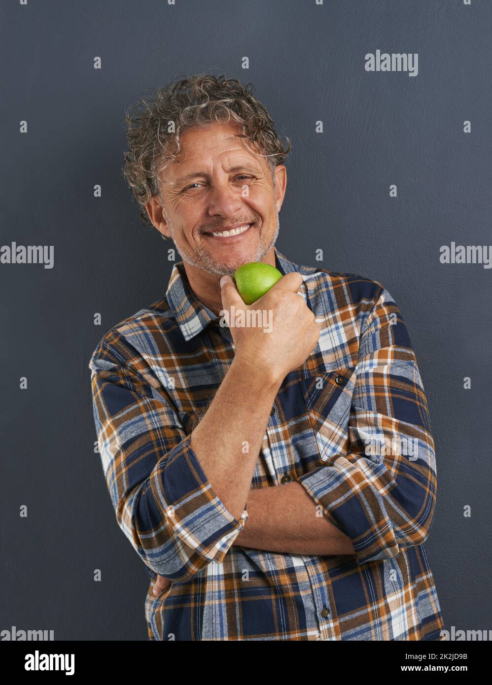 Scegliere uno stile di vita sano. Un ritratto di un uomo felice maturo che tiene una deliziosa mela. Foto Stock