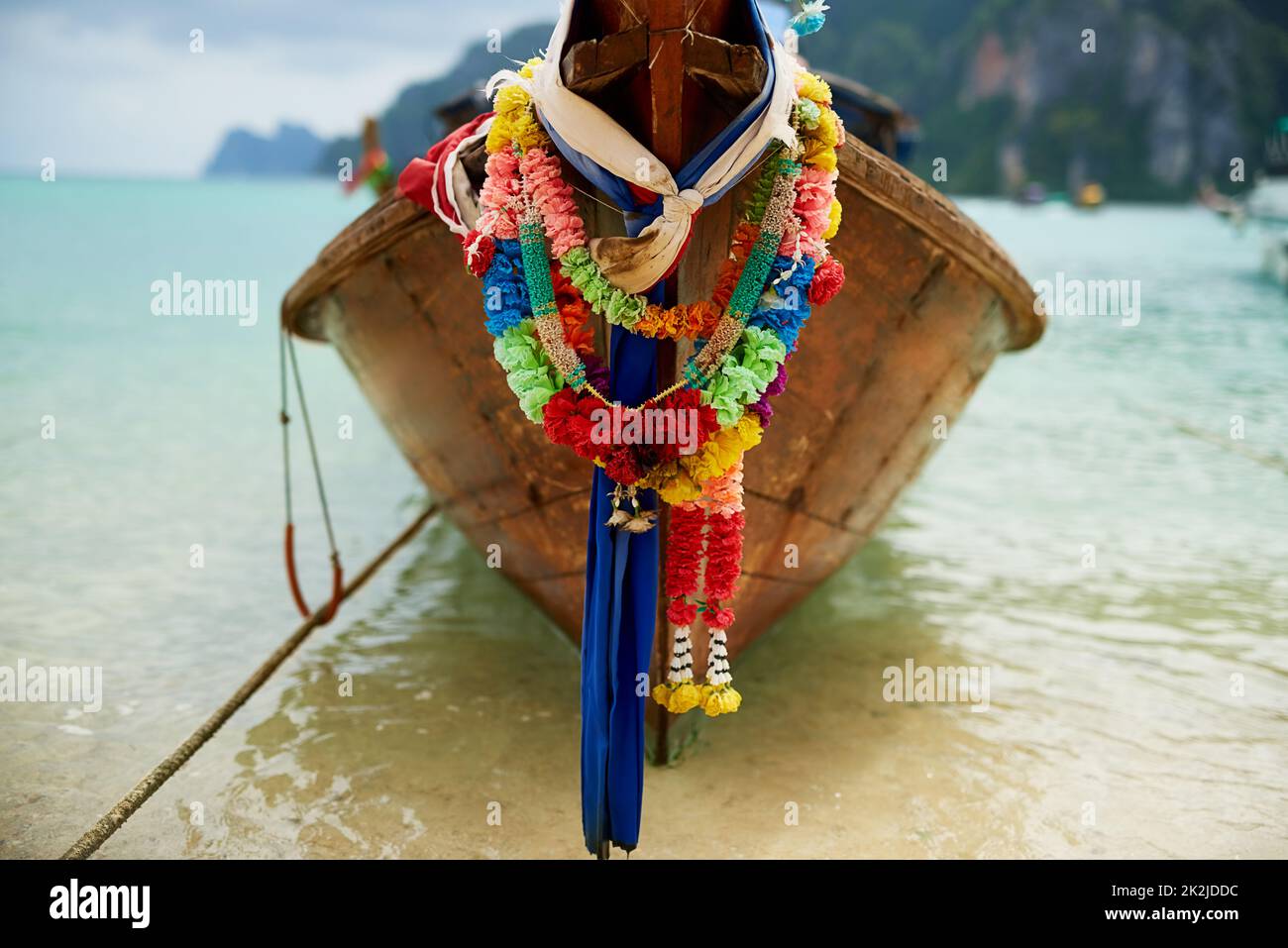 La vostra esperienza di barca isola vi aspetta.... Scatto di una barca sull'acqua con una ghirlanda floreale colorata appesa ad essa. Foto Stock