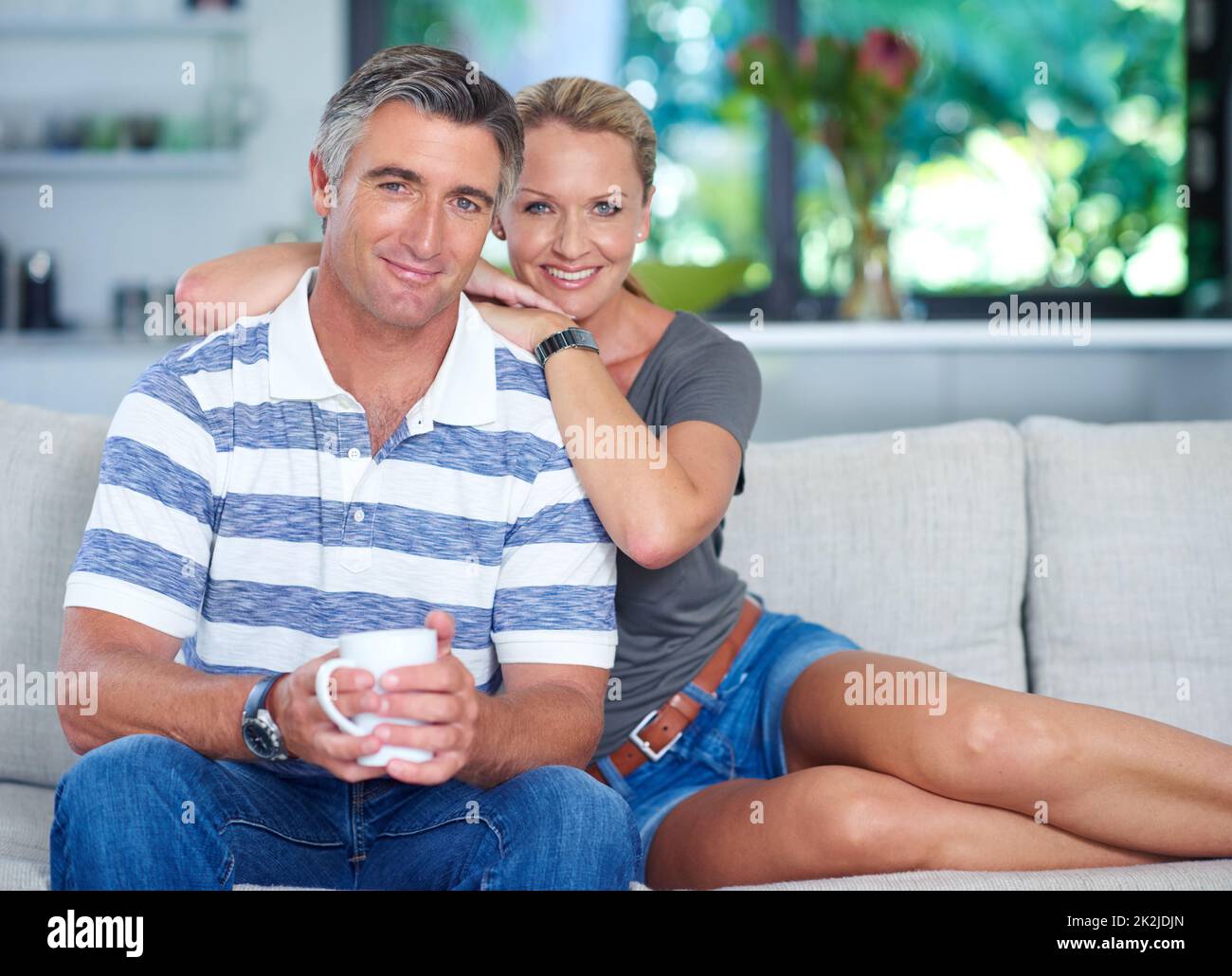 Giornata pigra a casa insieme. Ritratto di una coppia matura e amorevole che si rilassa sul divano di casa. Foto Stock