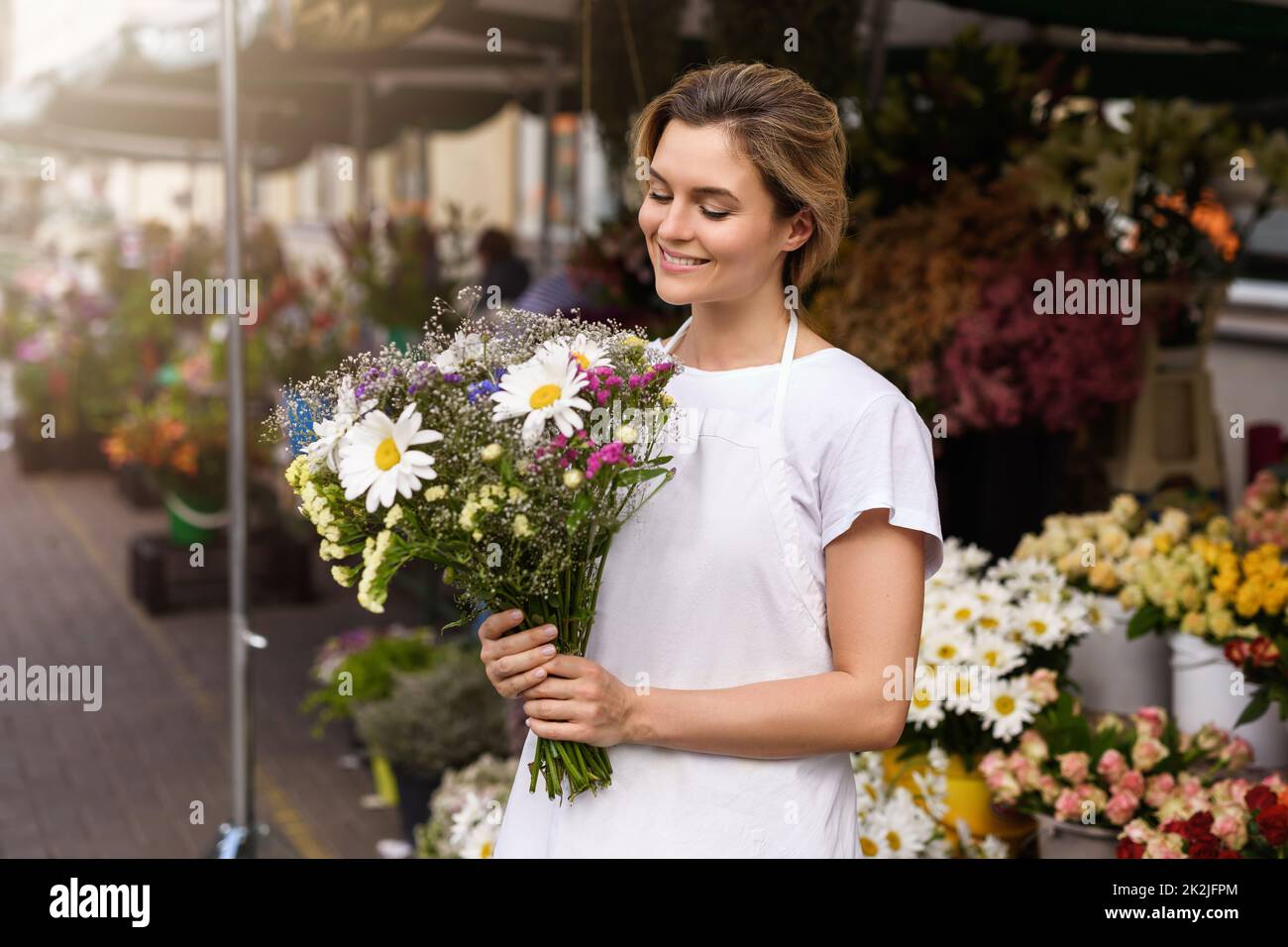 Fiorista donna con un bouquet di fiori selvatici nel suo piccolo negozio di fiori Foto Stock
