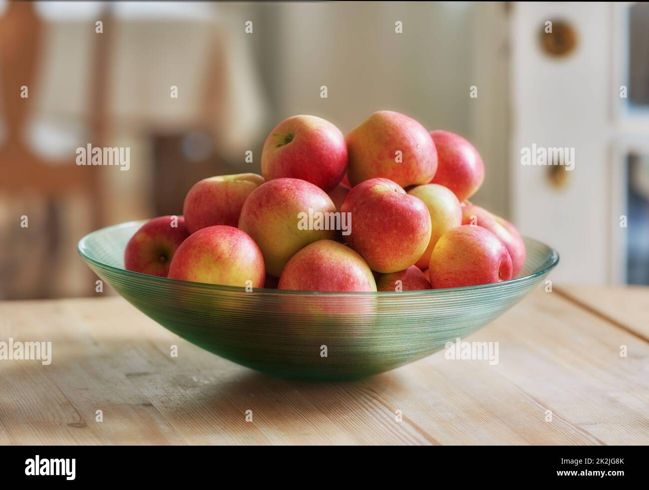 Una mela al giorno tiene il medico lontano. Ciotola di vetro con un sacco di mele sane - un vero piacere sano e allettante. Foto Stock