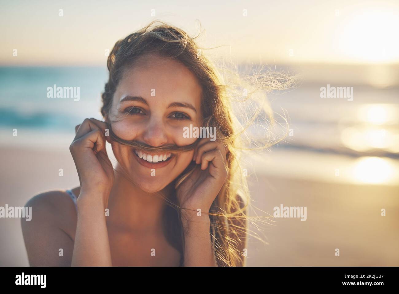 Il segreto della felicità è la libertà. Scatto ritagliato di una donna che fa un baffi giocosamente con i suoi capelli. Foto Stock