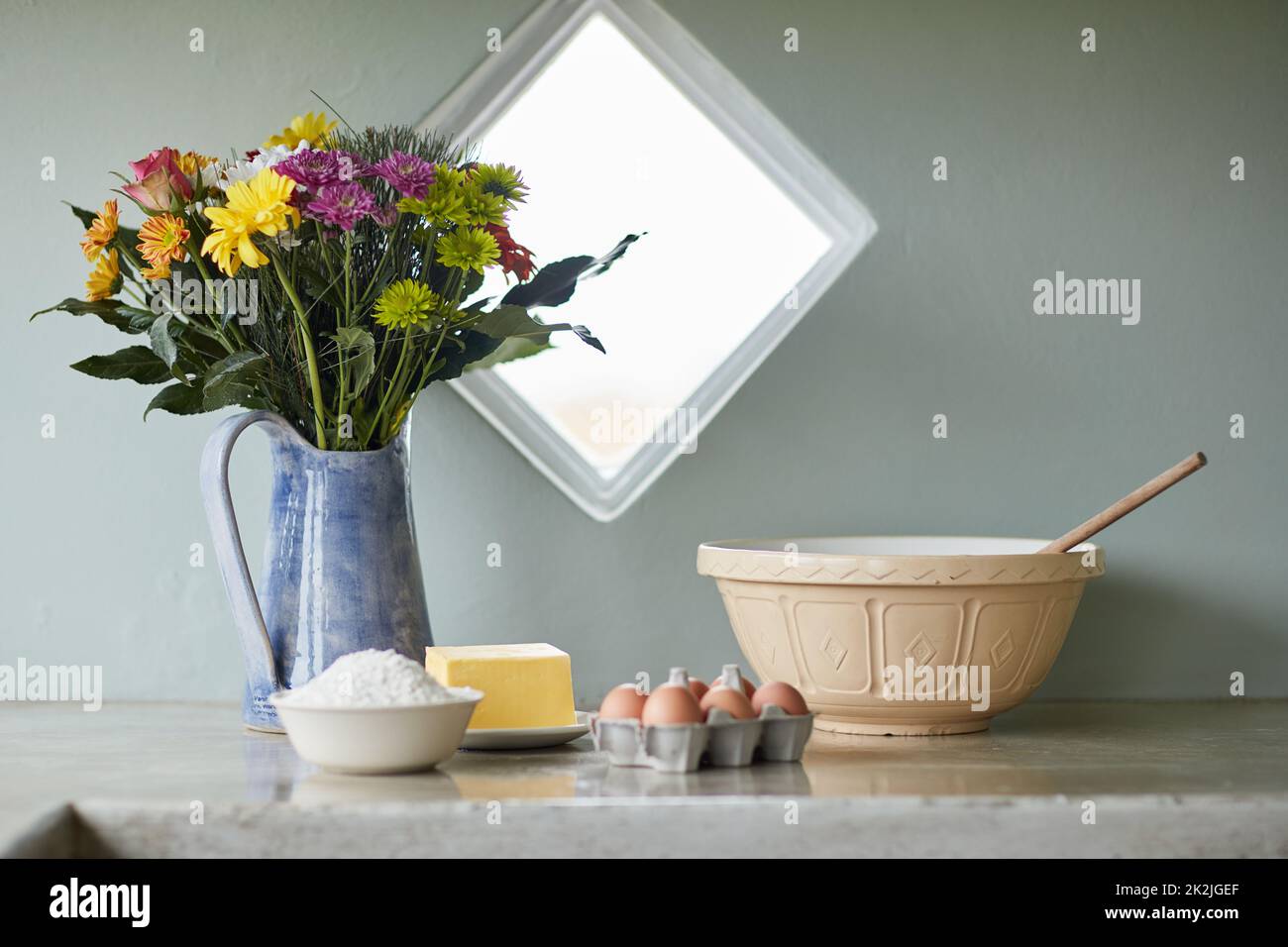 La felicità è fatta in casa. Shot di un bancone con ingredienti da forno disposti su di esso in una cucina di campagna. Foto Stock
