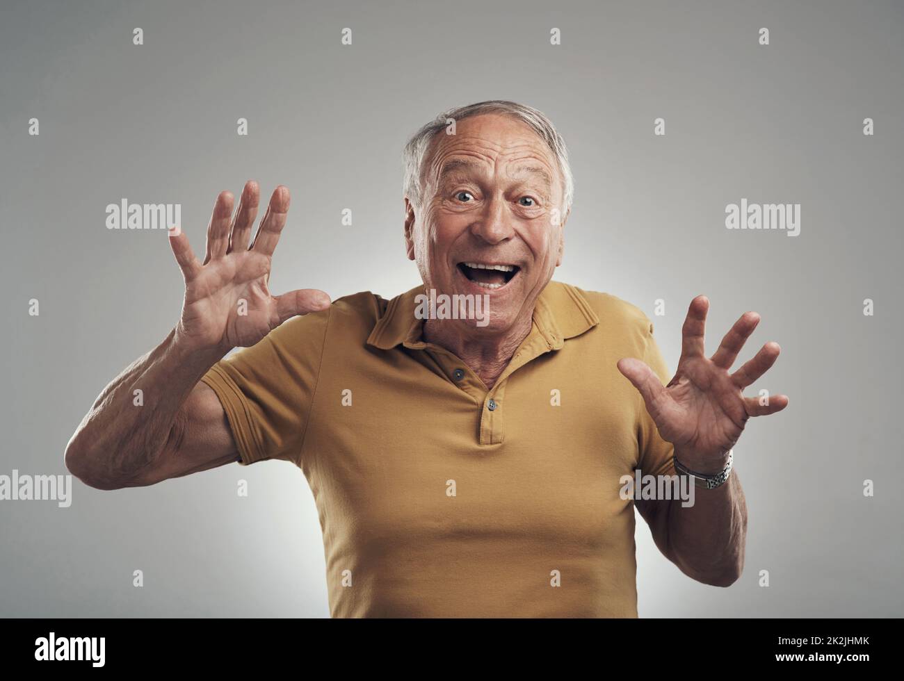 Sorpresa. Studio girato di un uomo anziano ottenendo una sorpresa su uno sfondo grigio. Foto Stock