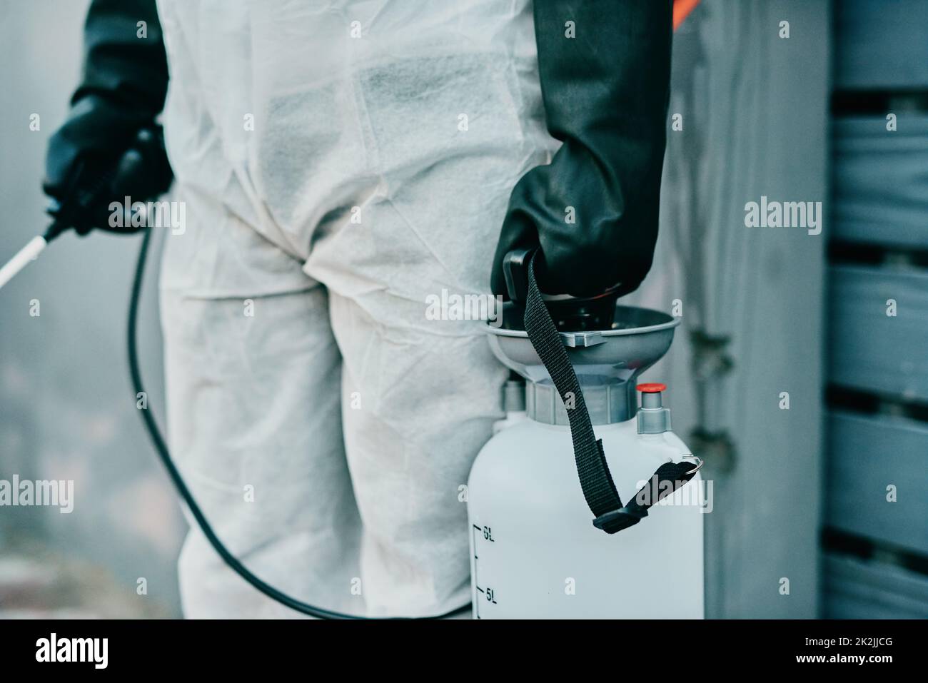 L'exterminatore del virus. Sparato di un operatore sanitario che indossa un tuta di nocciola che lavora per controllare un focolaio. Foto Stock