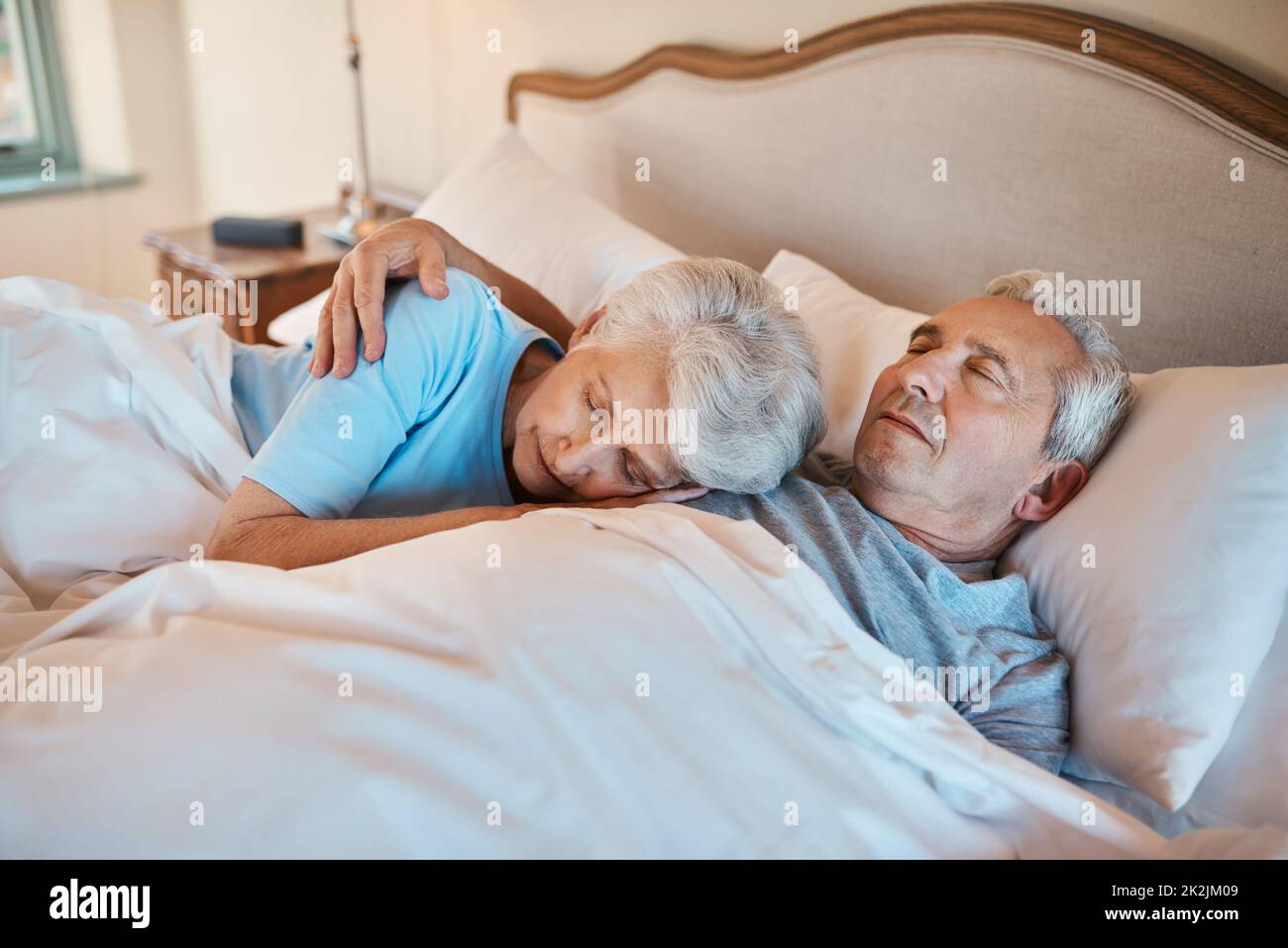 Ive ha ascoltato questo battito cardiaco per anni. Scatto corto di una coppia anziana affettuosa che si coccola mentre dormono a letto in una casa di cura. Foto Stock