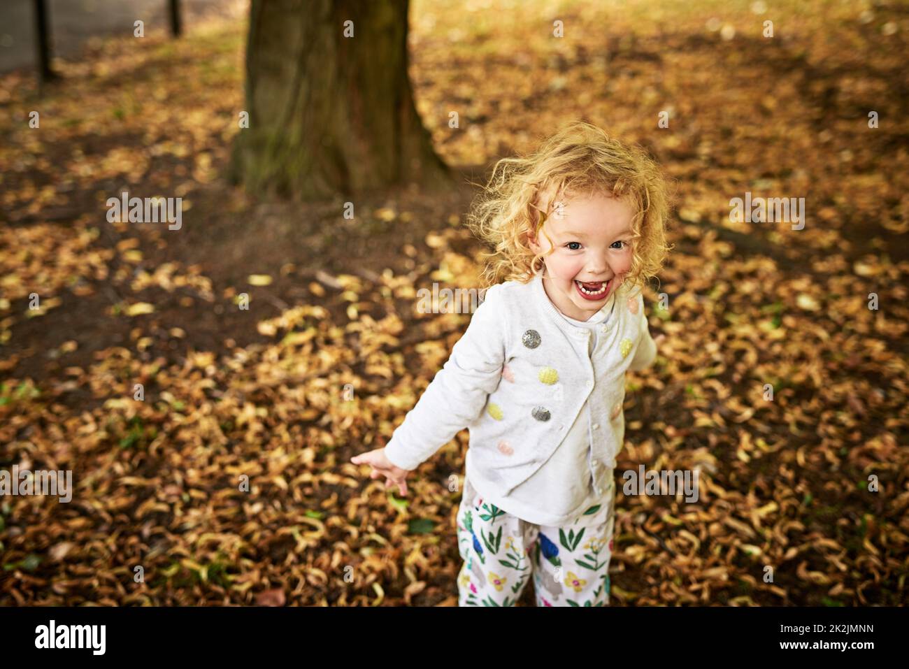 Insegnate ai bambini ad apprezzare la bellezza della natura. Scatto di una bambina adorabile che si diverte all'aperto. Foto Stock