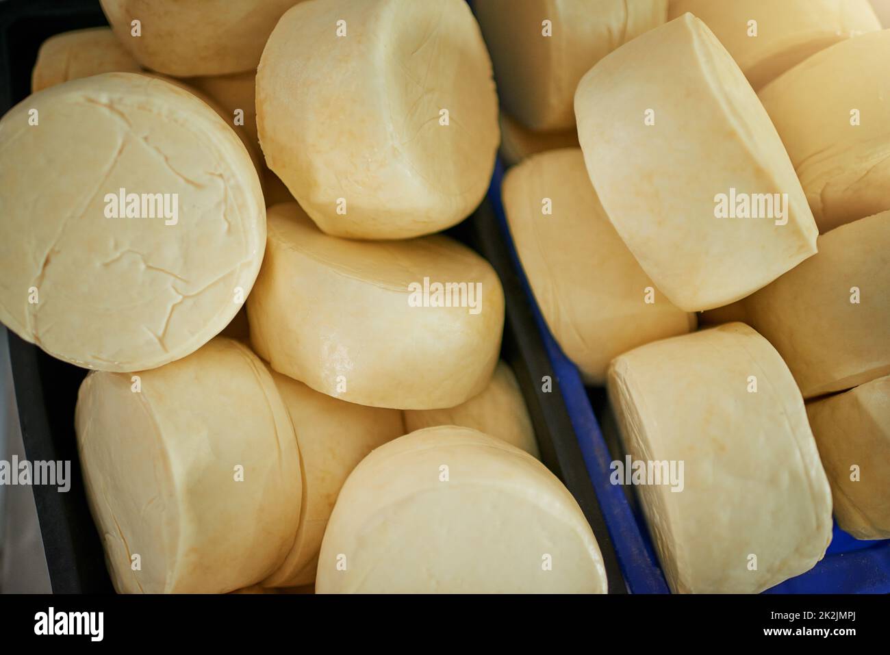 L'industria casearia va in giro. Colpo ad angolo elevato di ruote di formaggio in una fabbrica in un caseificio. Foto Stock