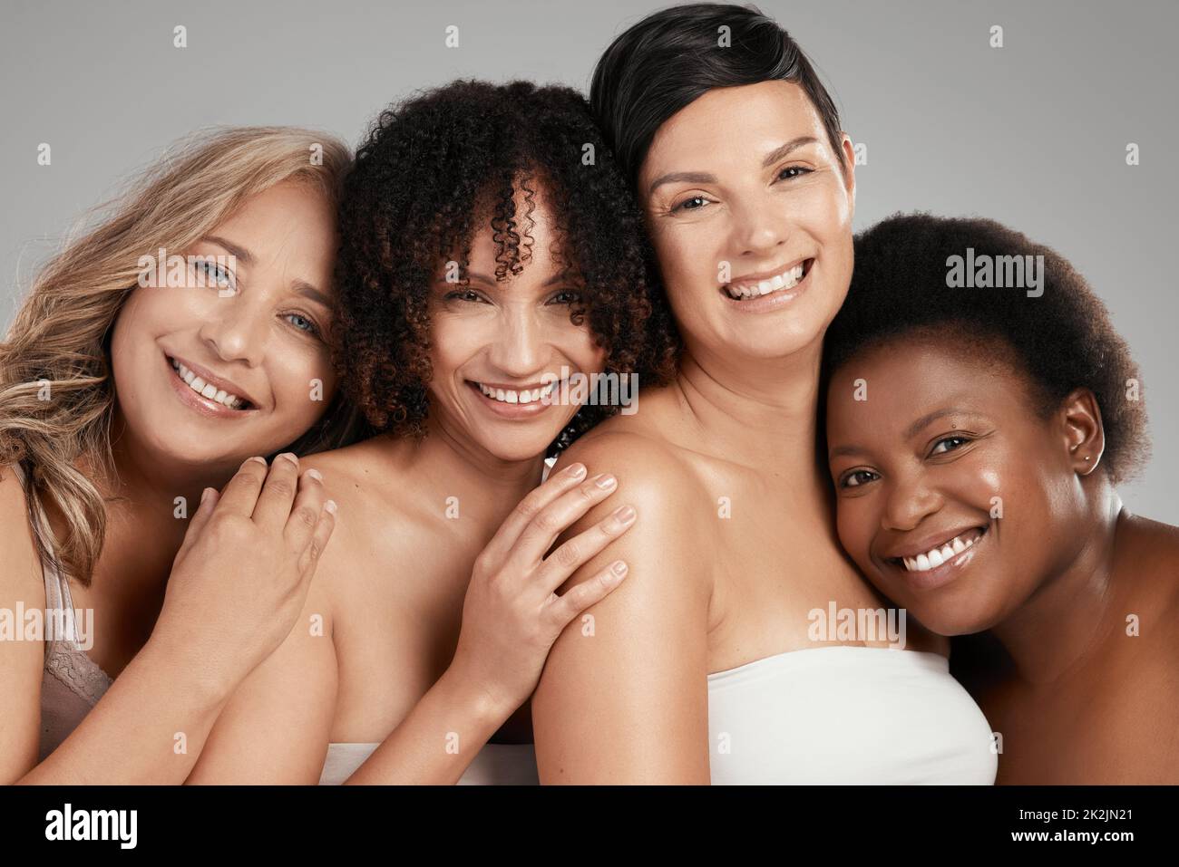 Voi crescete dove vi sentite accettati. Girato di un gruppo diversificato di donne in piedi e abbracciarsi l'un l'altro in studio. Foto Stock