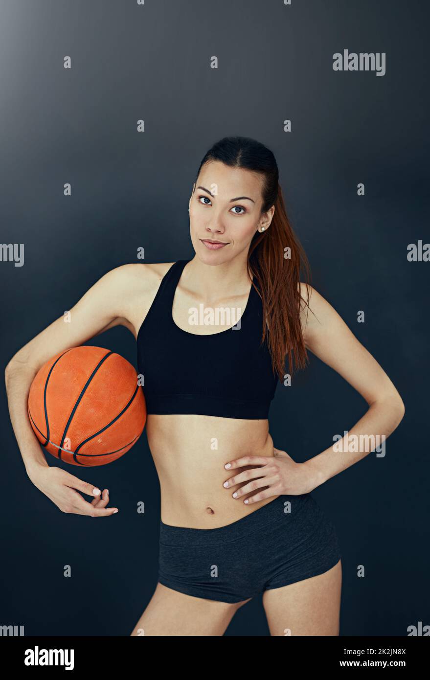 Gioco ottenuto. Studio ritratto di una giovane donna attraente in possesso di una basket. Foto Stock