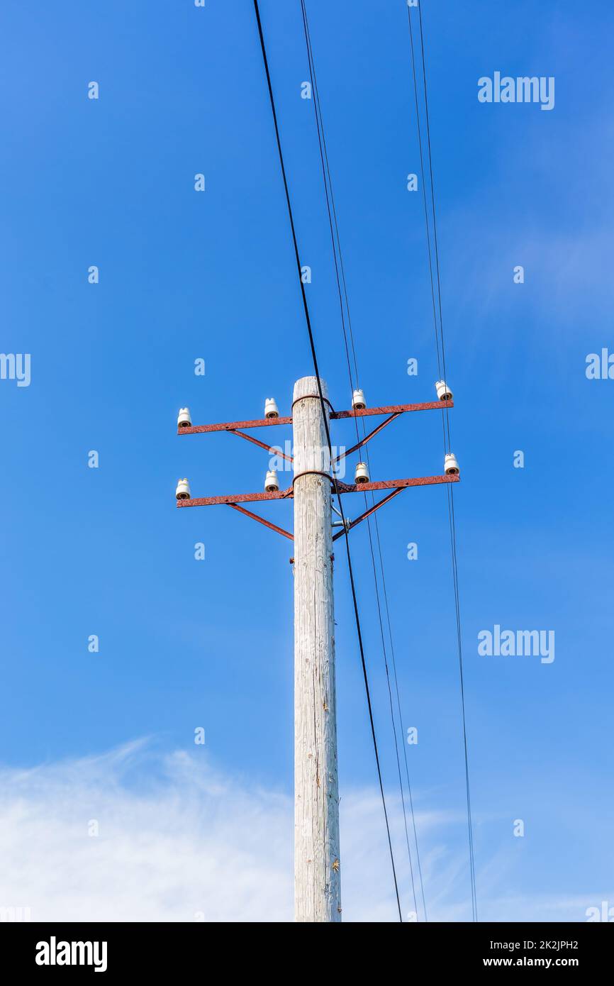Vecchia linea telefonica Rusty contro un cielo estivo blu chiaro Foto Stock