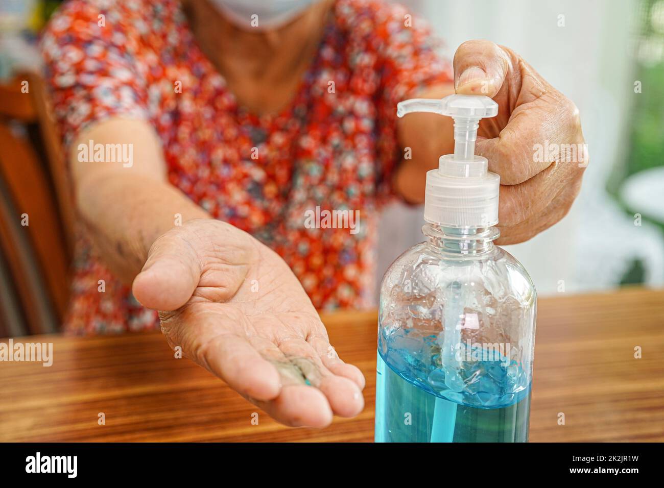 Paziente anziana asiatica che indossa una maschera protettiva per proteggere l'ambiente inquinante e il coronavirus COVID-19. Foto Stock