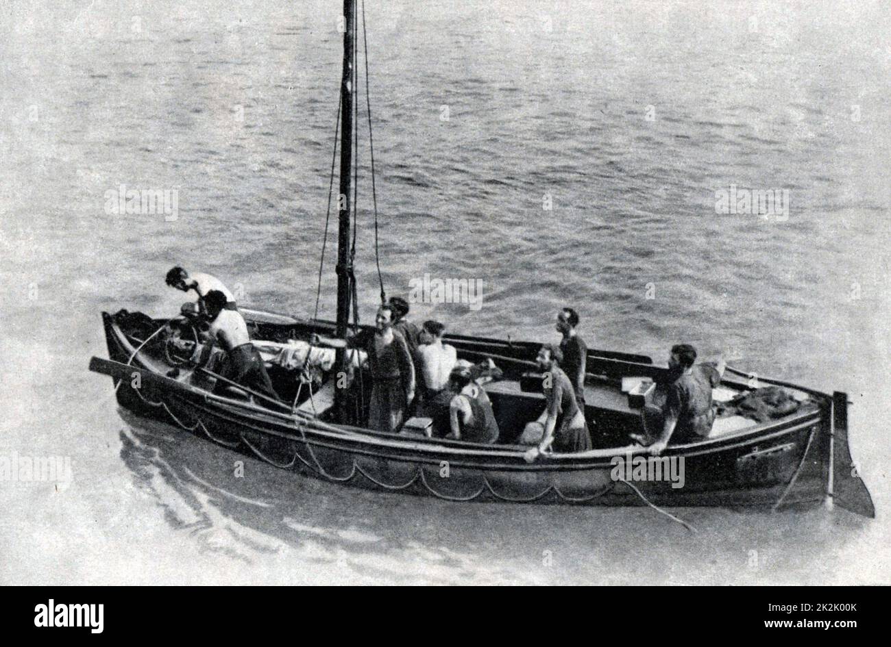 Marinai mercantili britannici in procinto di essere imbarcati su una nave da guerra britannica. Dopo che la loro nave era stata affondata, sono stati deragliati in una scialuppa di salvataggio per dieci giorni con pochi biscotti e un po' d'acqua. Foto Stock