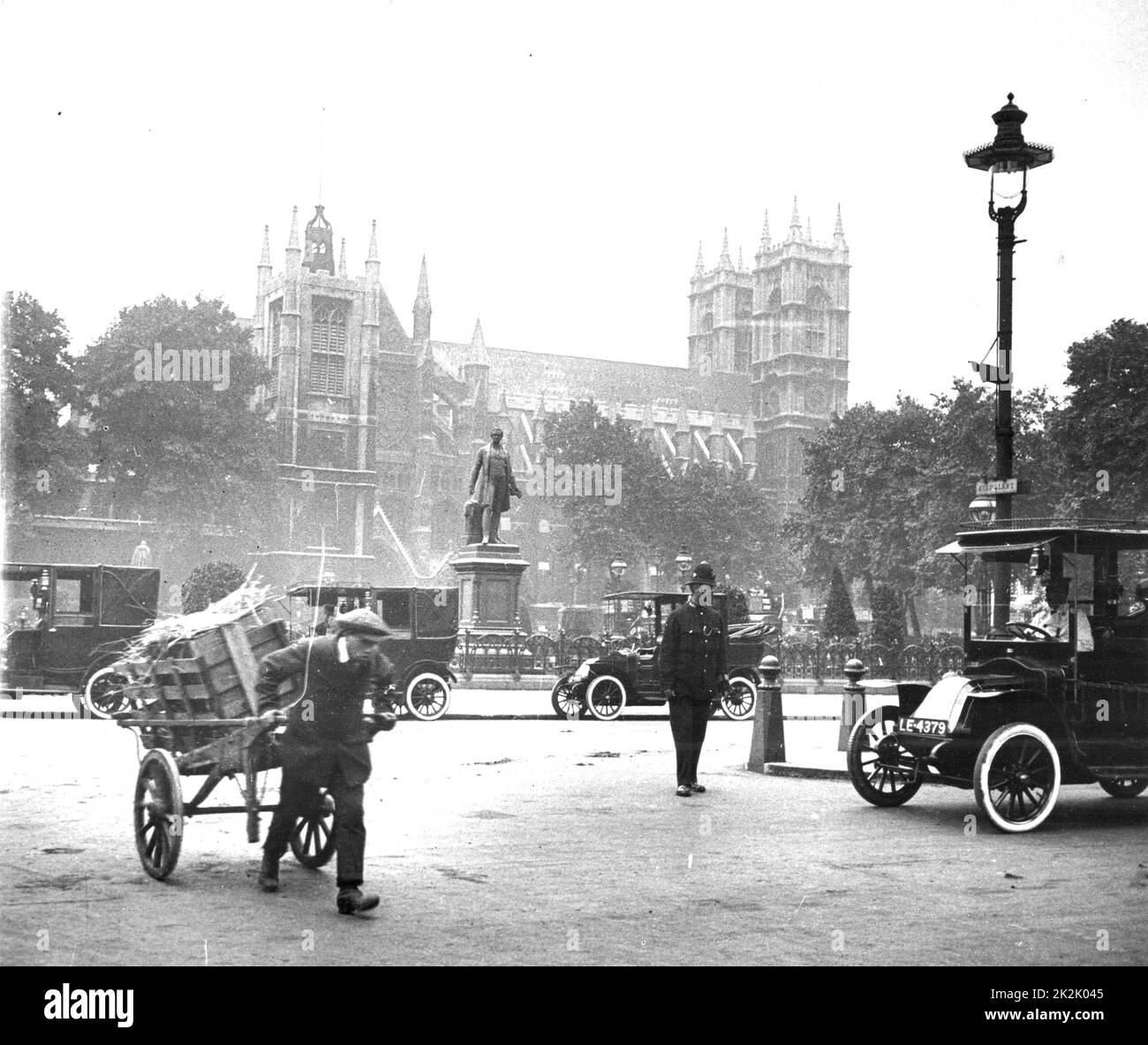 Scena di strada, Westminster, London, con auto, ragazzo con camion e poliziotto sul dazio, c 1910. Fotografia. Foto Stock