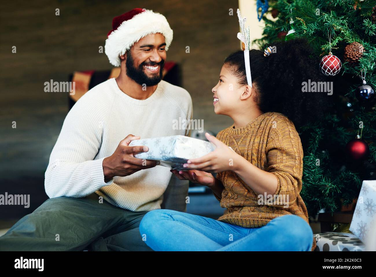 Indovina cosa ti ha portato Babbo Natale. Scatto di una ragazza carina che  apre presenta con suo padre durante il Natale a casa Foto stock - Alamy