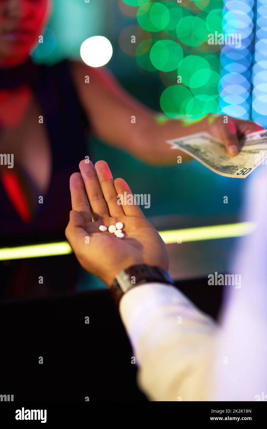 Cosa succede nel nightclub.... Closeup shot di una donna che acquista farmaci da un uomo in un nightclub. Foto Stock