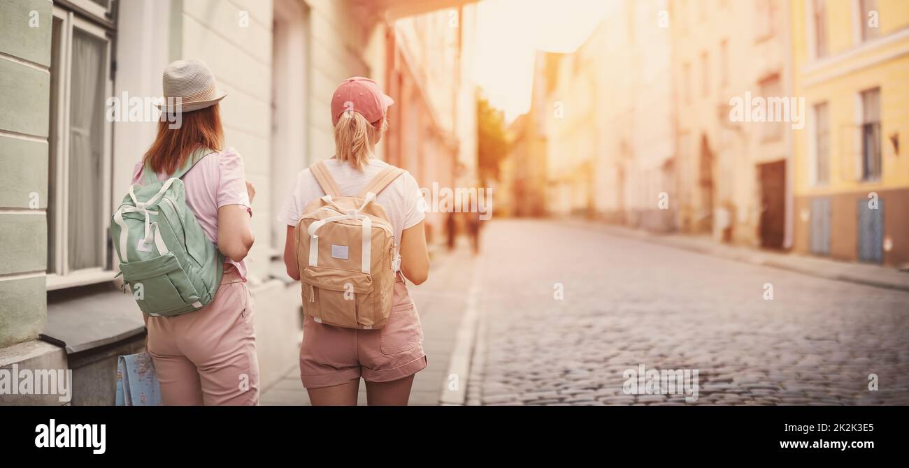 Due donne con zaini che camminano nella vecchia Tallinn, Estonia. Foto Stock