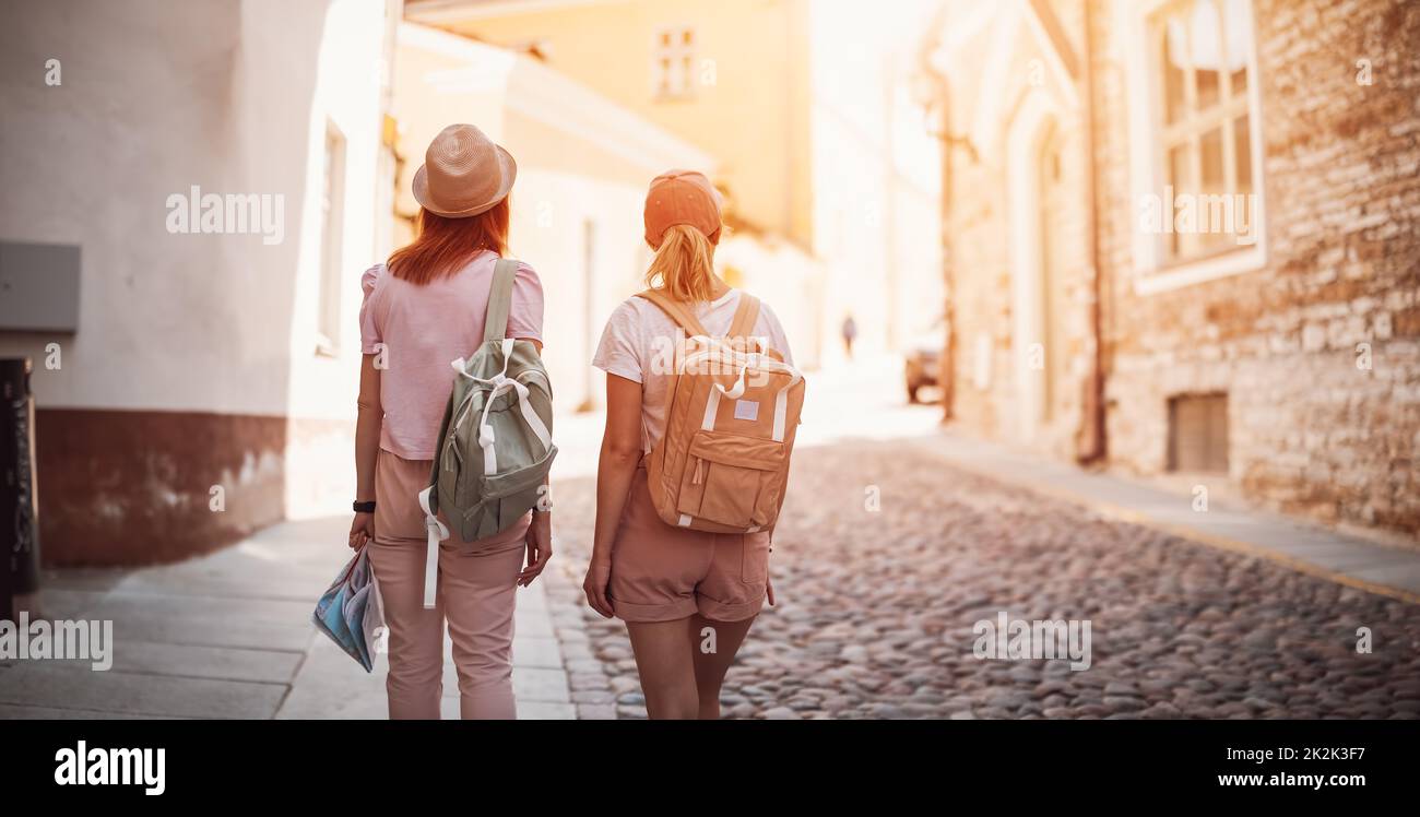 Due donne con zaini che camminano nella vecchia Tallinn, Estonia. Foto Stock