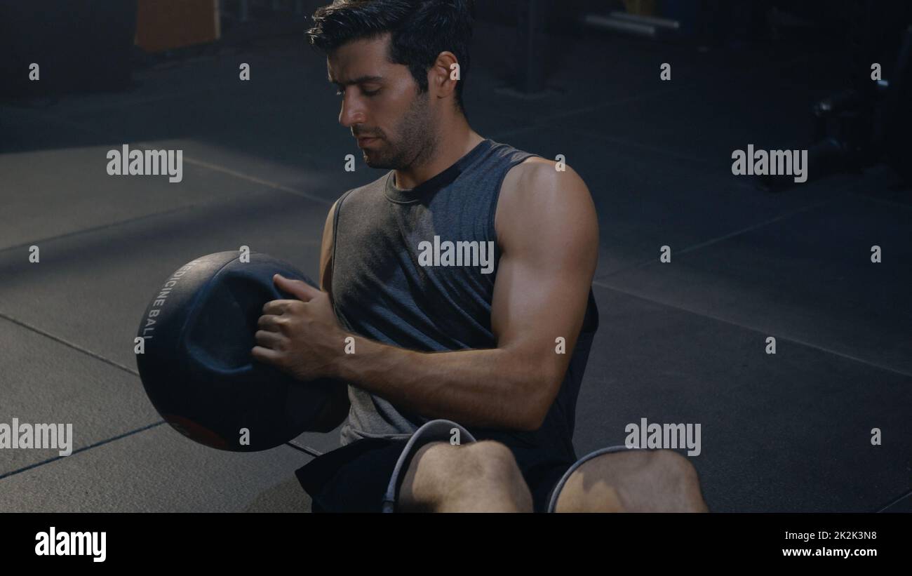 l'uomo atletico muscolare che fa esercizi di allenamento addome allenandosi con una palla medica Foto Stock