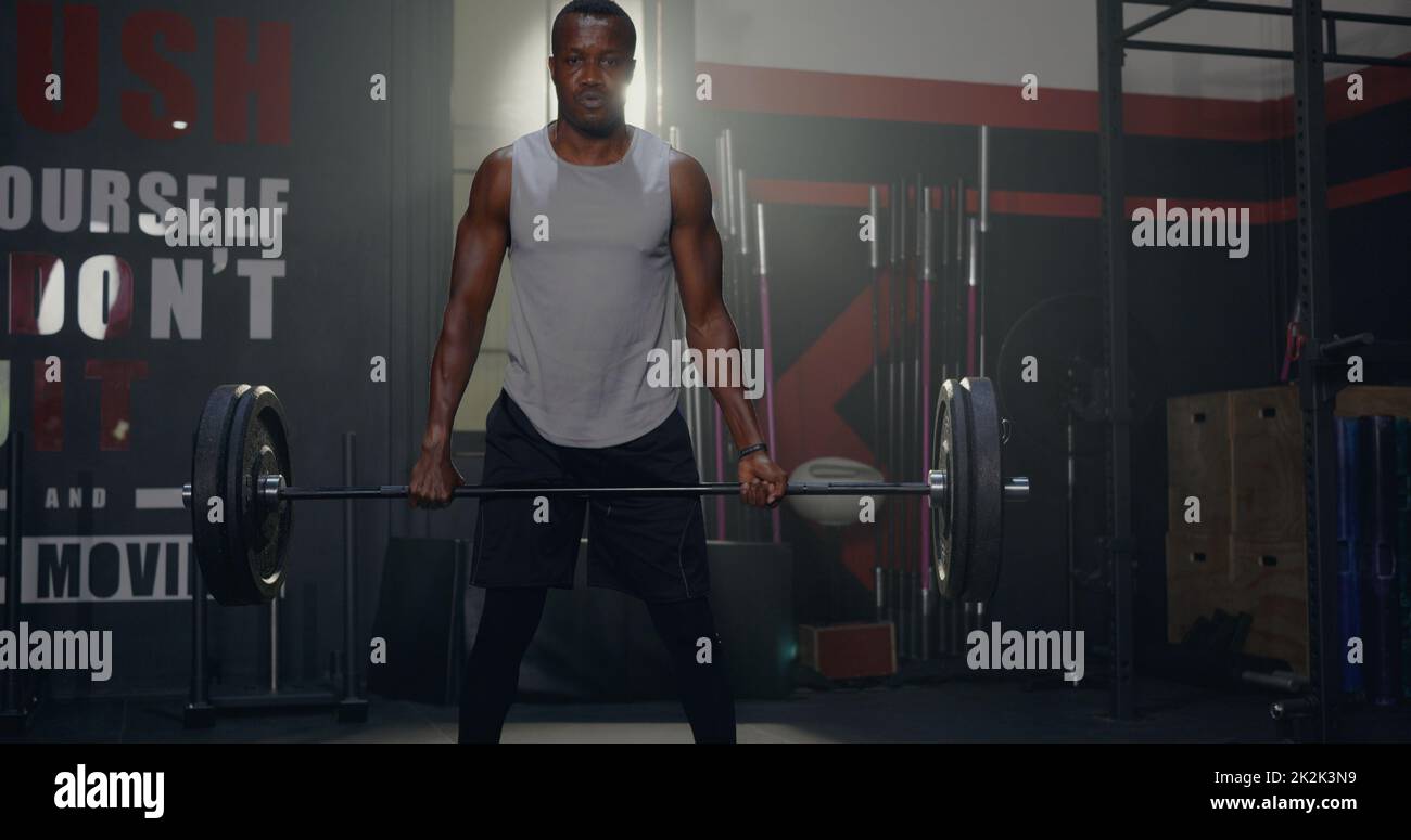Muscolare giovane uomo nero esercizi di allenamento con sollevamento pesi pesante Barbell Foto Stock
