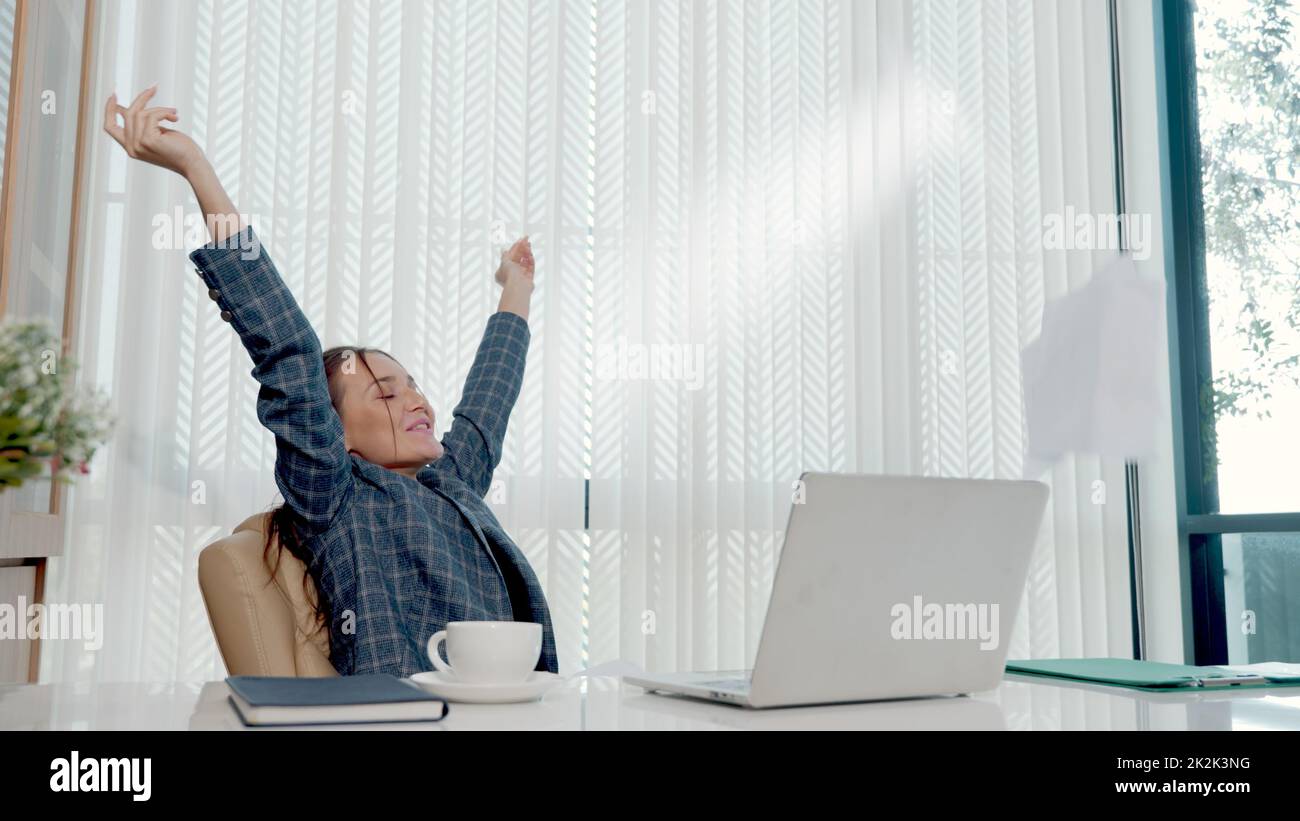Felice donna d'affari entusiasta ha sorpreso il lavoro alla scrivania bianca dell'ufficio con un pc portatile che getta documenti cartacei dell'account Foto Stock Felice donna d'affari entusiasta ha sorpreso il lavoro alla scrivania bianca dell'ufficio con un pc portatile che getta documenti cartacei dell'account Foto Stock