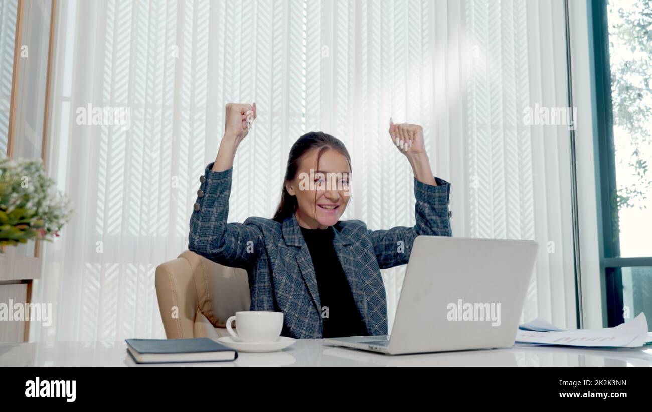 Felice donna d'affari entusiasta ha sorpreso il lavoro alla scrivania bianca dell'ufficio con un pc portatile che getta documenti cartacei dell'account Foto Stock Felice donna d'affari entusiasta ha sorpreso il lavoro alla scrivania bianca dell'ufficio con un pc portatile che getta documenti cartacei dell'account Foto Stock