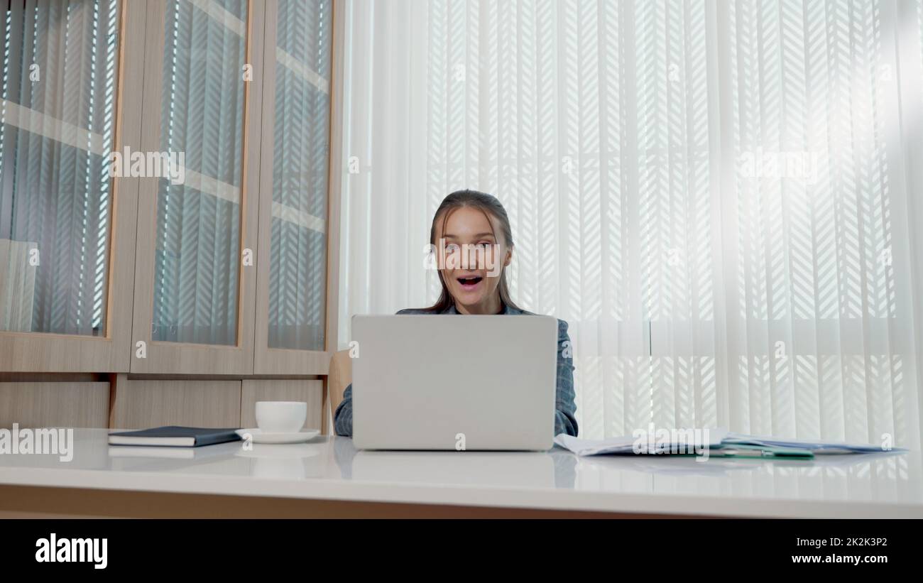 Felice donna d'affari entusiasta ha sorpreso il lavoro alla scrivania bianca dell'ufficio con un pc portatile che getta documenti cartacei dell'account Foto Stock Felice donna d'affari entusiasta ha sorpreso il lavoro alla scrivania bianca dell'ufficio con un pc portatile che getta documenti cartacei dell'account Foto Stock