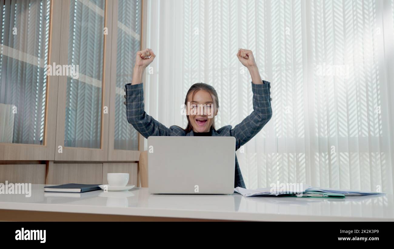 Felice donna d'affari entusiasta ha sorpreso il lavoro alla scrivania bianca dell'ufficio con un pc portatile che getta documenti cartacei dell'account Foto Stock Felice donna d'affari entusiasta ha sorpreso il lavoro alla scrivania bianca dell'ufficio con un pc portatile che getta documenti cartacei dell'account Foto Stock