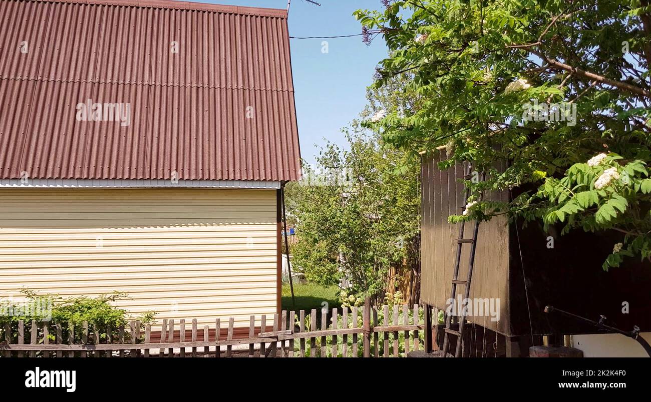 moderna casa rurale autentica con siding e annessi nel cortile, il concetto di vita estiva in campagna Foto Stock