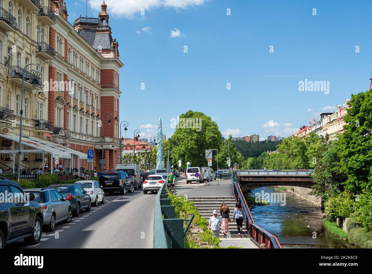 Karlovy Vary, Repubblica Ceca - 26 maggio 2017: Strada nel centro della città con ristorante e ponte sul fiume Foto Stock
