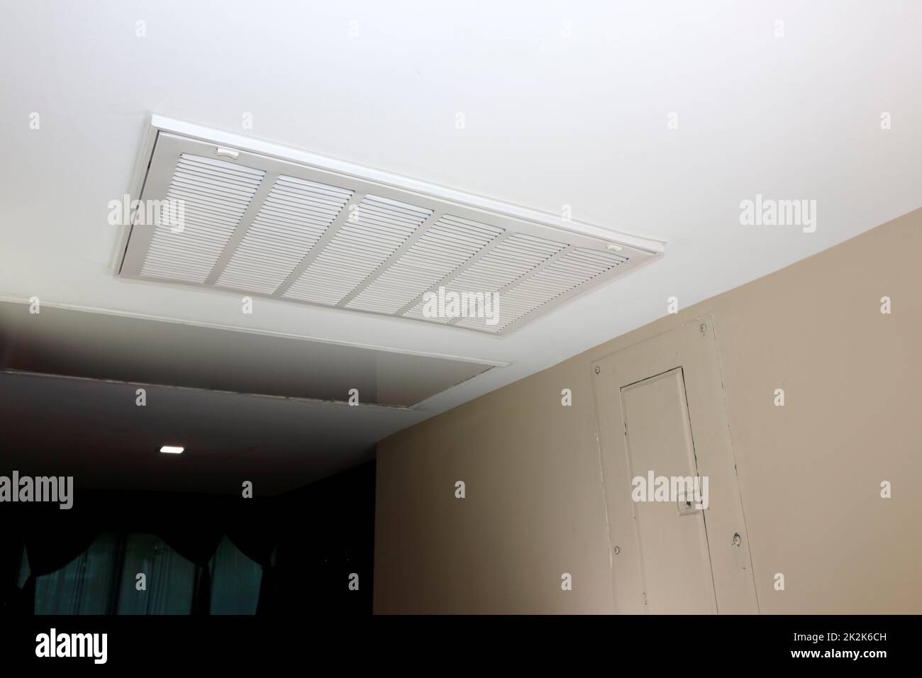 Griglia di ventilazione a ritorno d'aria HVAC rettangolare bianca in un soffitto domestico Foto Stock