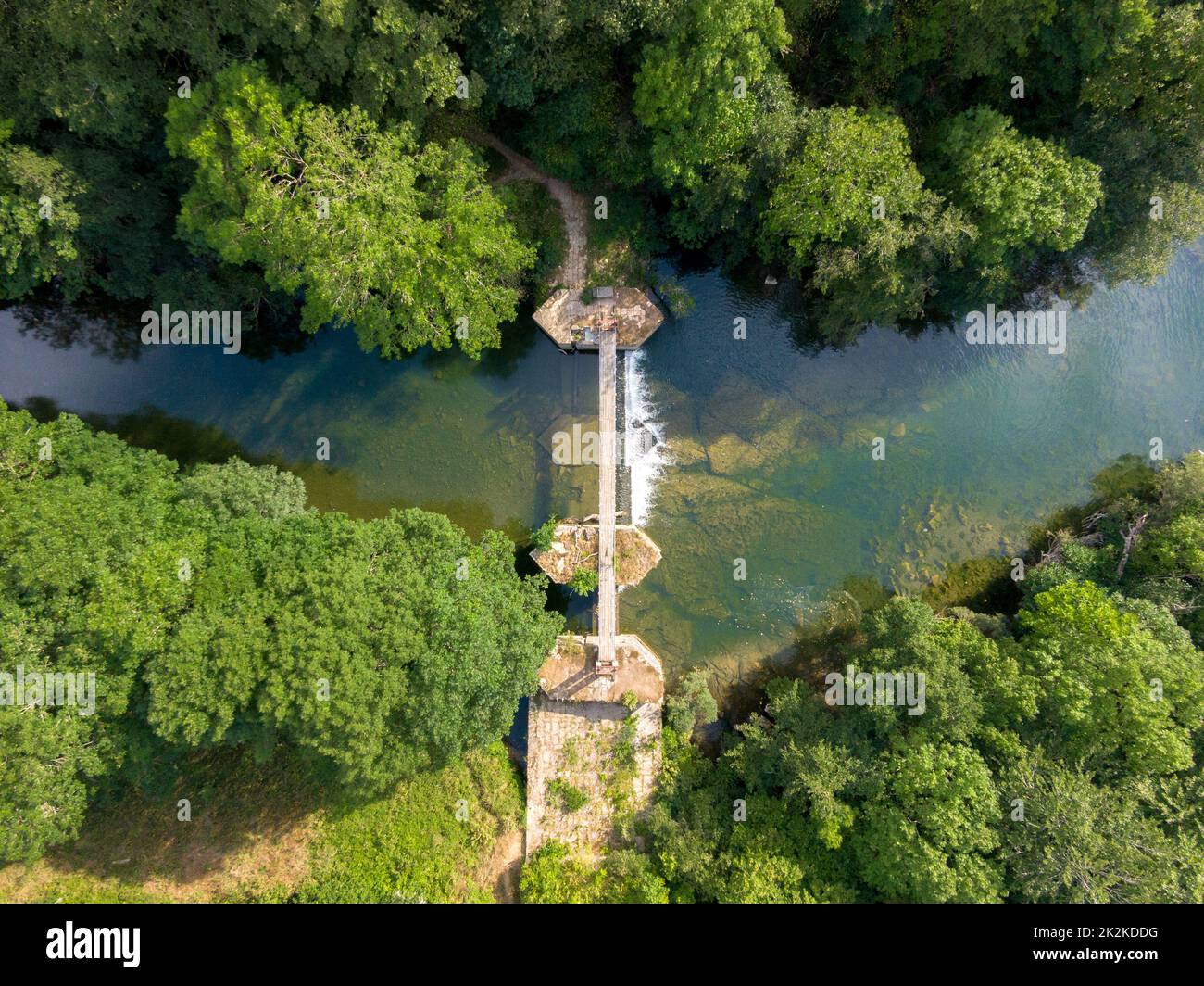 Vista dall'alto di un ponte sospeso in legno sul cristallino fiume Irati. Foto Stock