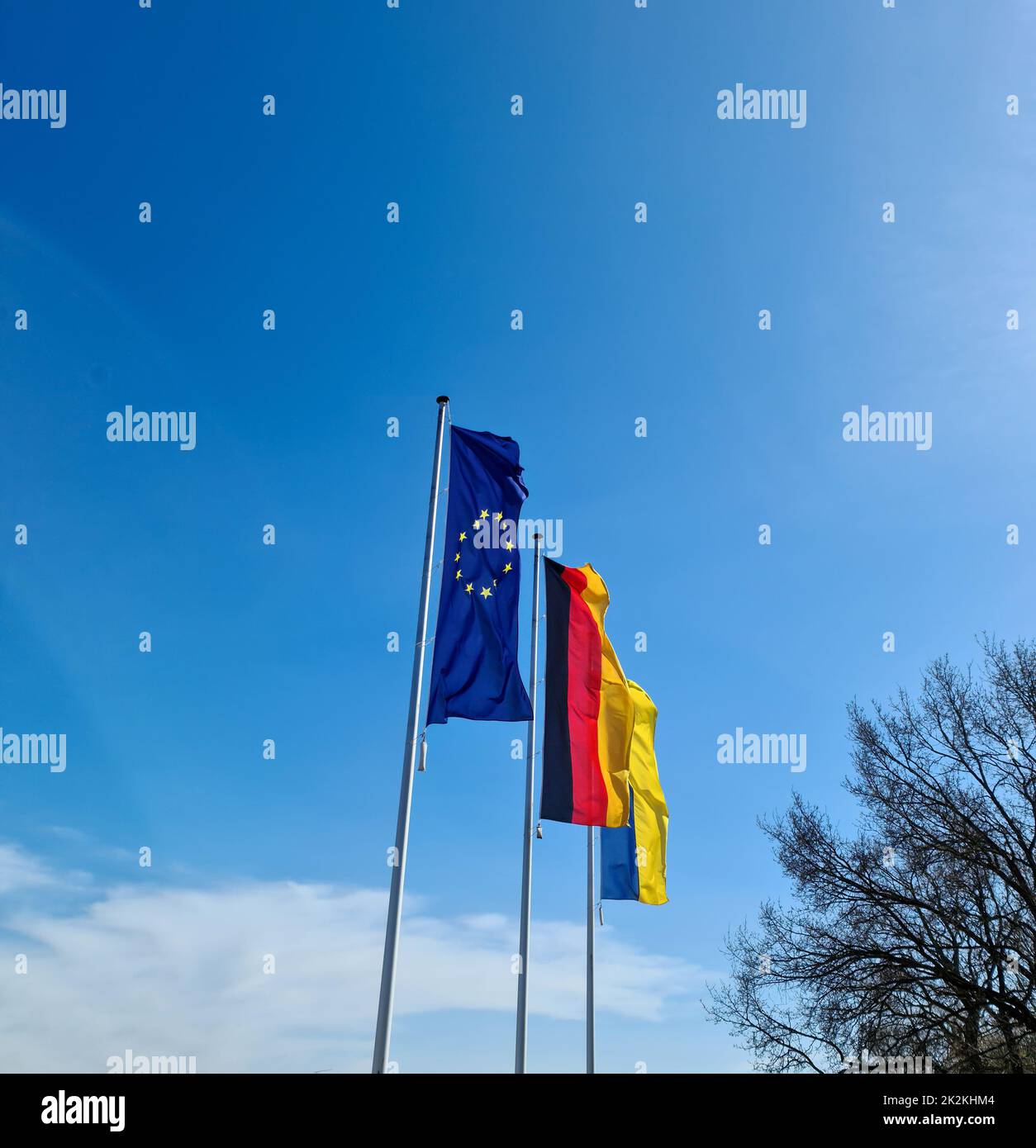 Le bandiere di Ucraina, Germania e Unione europea volano fianco a fianco contro il cielo blu. Foto Stock