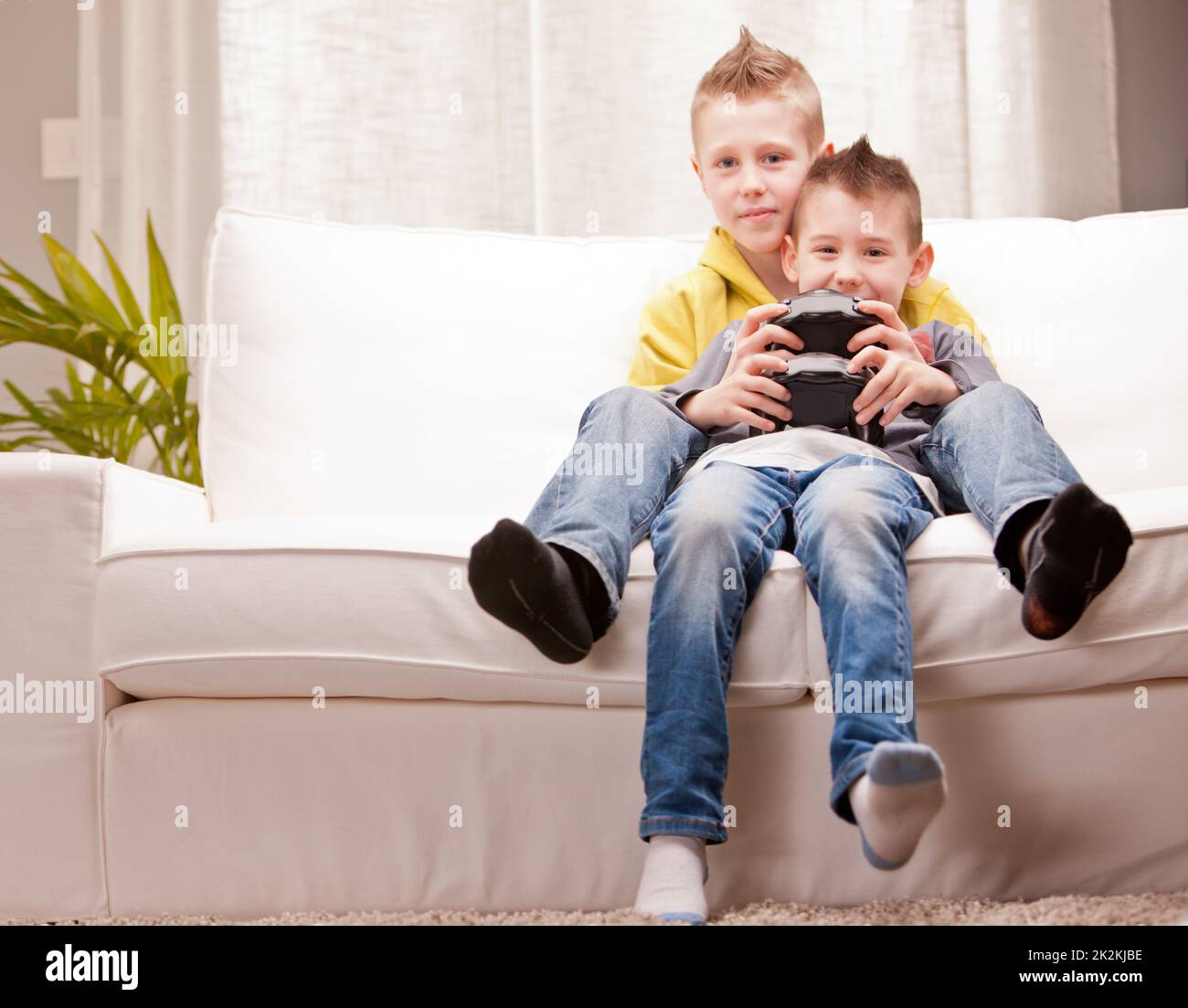 piccoli fratelli che giocano insieme ai videogiochi Foto Stock