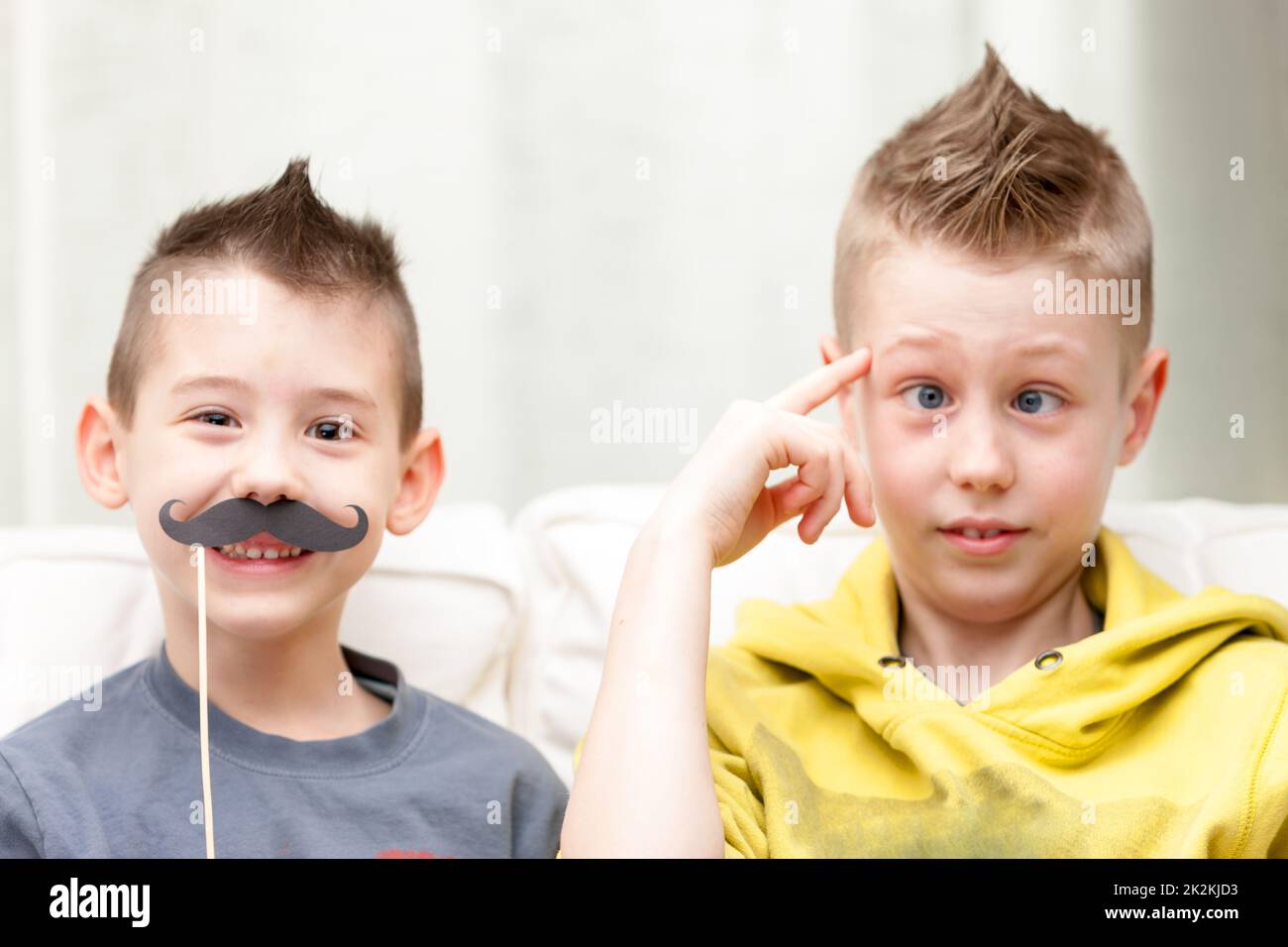 coppia di piccoli fratelli che fanno volti divertenti Foto Stock