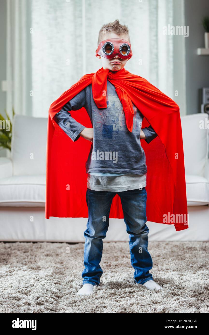 Determinato Super Hero giovane in un mantello colorato rosso Foto Stock
