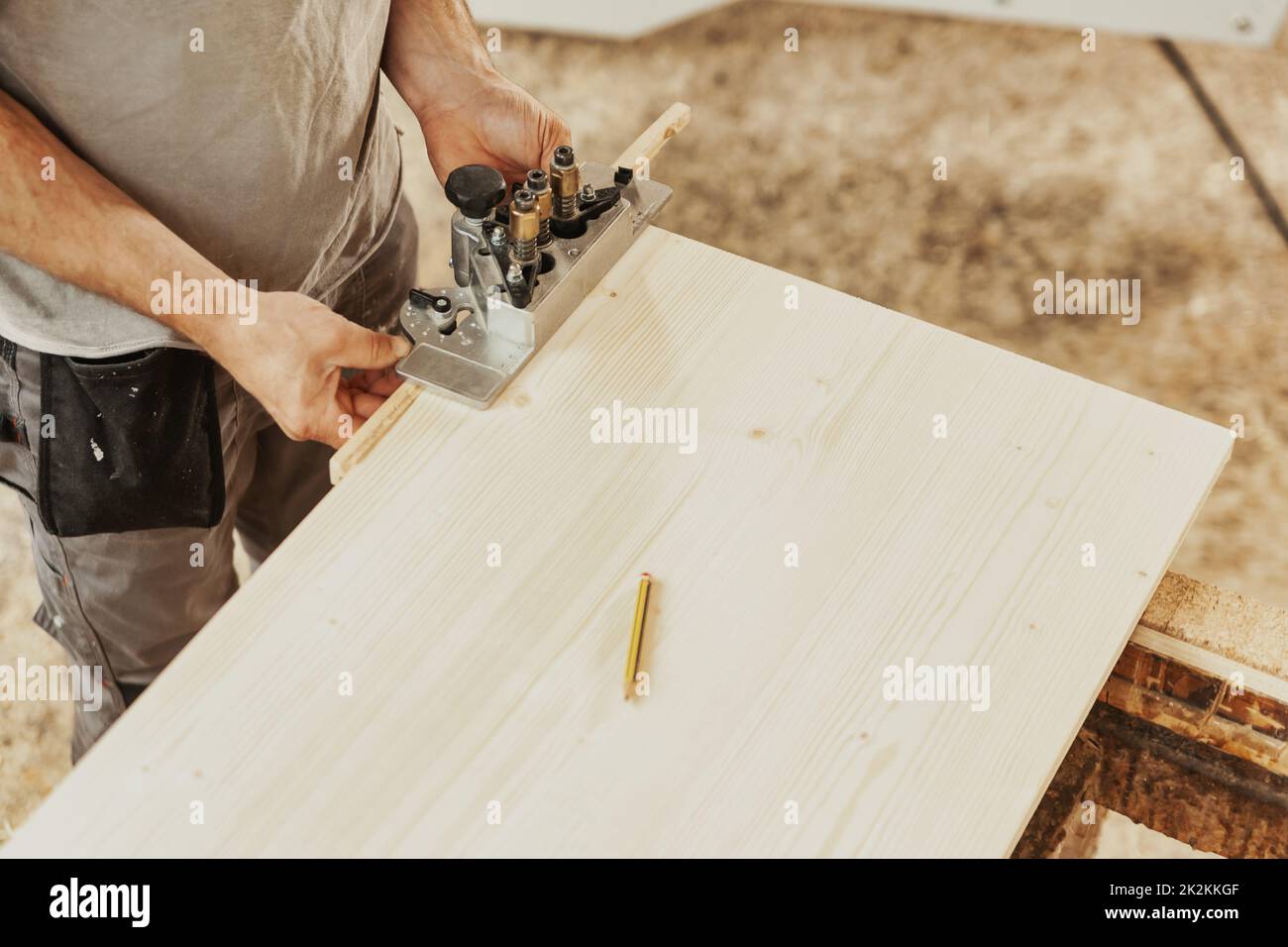 Falegname che lavora su un pannello o una lamiera di legno in un'officina Foto Stock