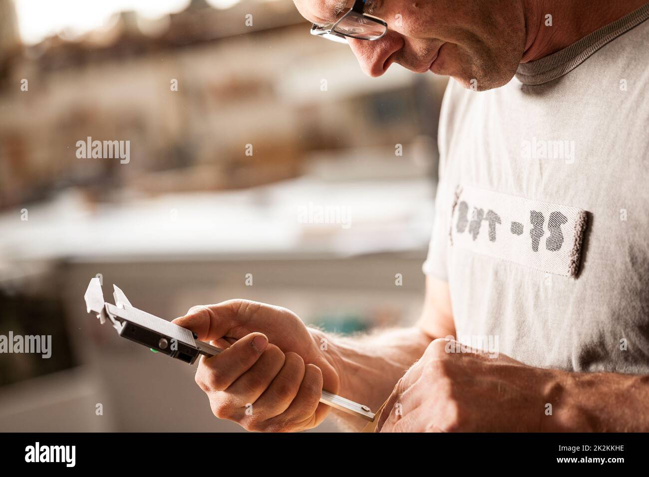 woodworker che misura con il suo calibro Foto Stock