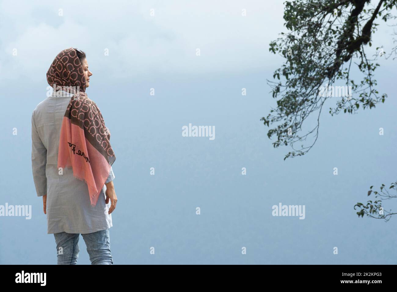 Punto di vista posteriore di una giovane donna musulmana godendo nel misty Foto Stock