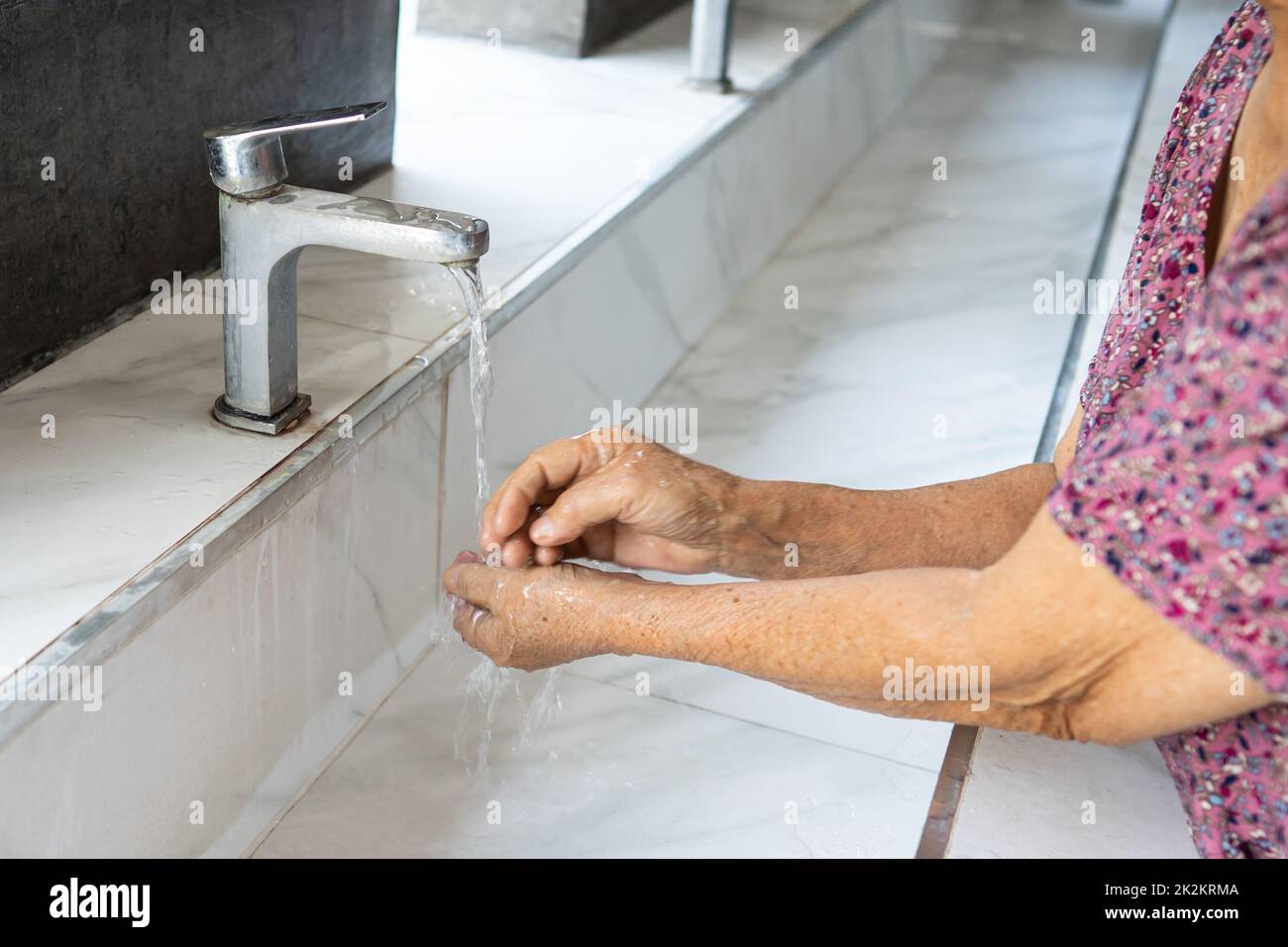 Donna anziana asiatica o anziana donna che si lava la mano con sapone e acqua pulita per proteggere l'infezione di sicurezza e uccidere il virus Coronavirus Covid-19, batteri e germi. Foto Stock