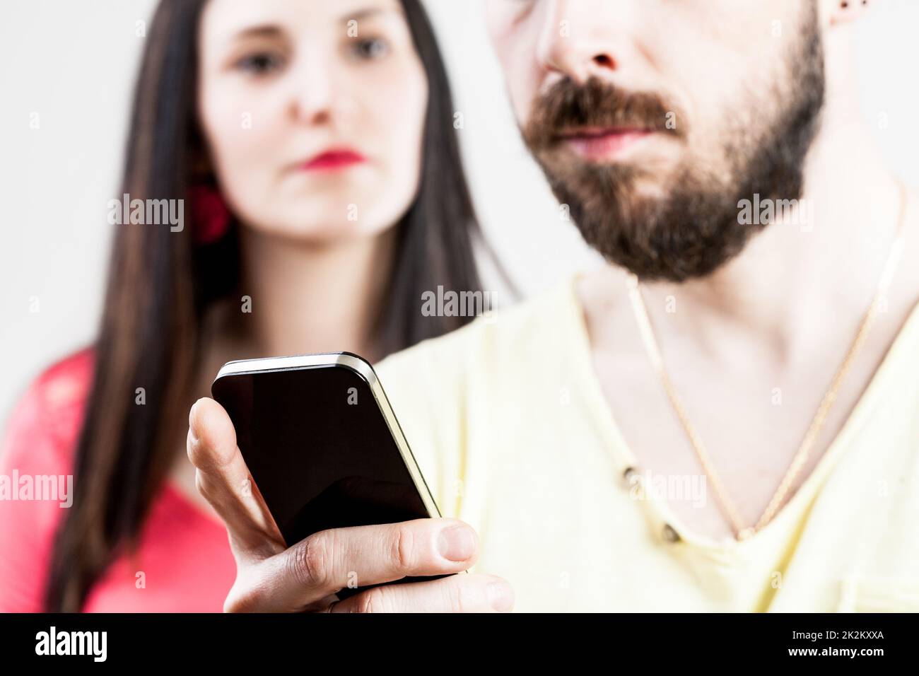donna delusa per il suo uomo sul suo cellulare Foto Stock