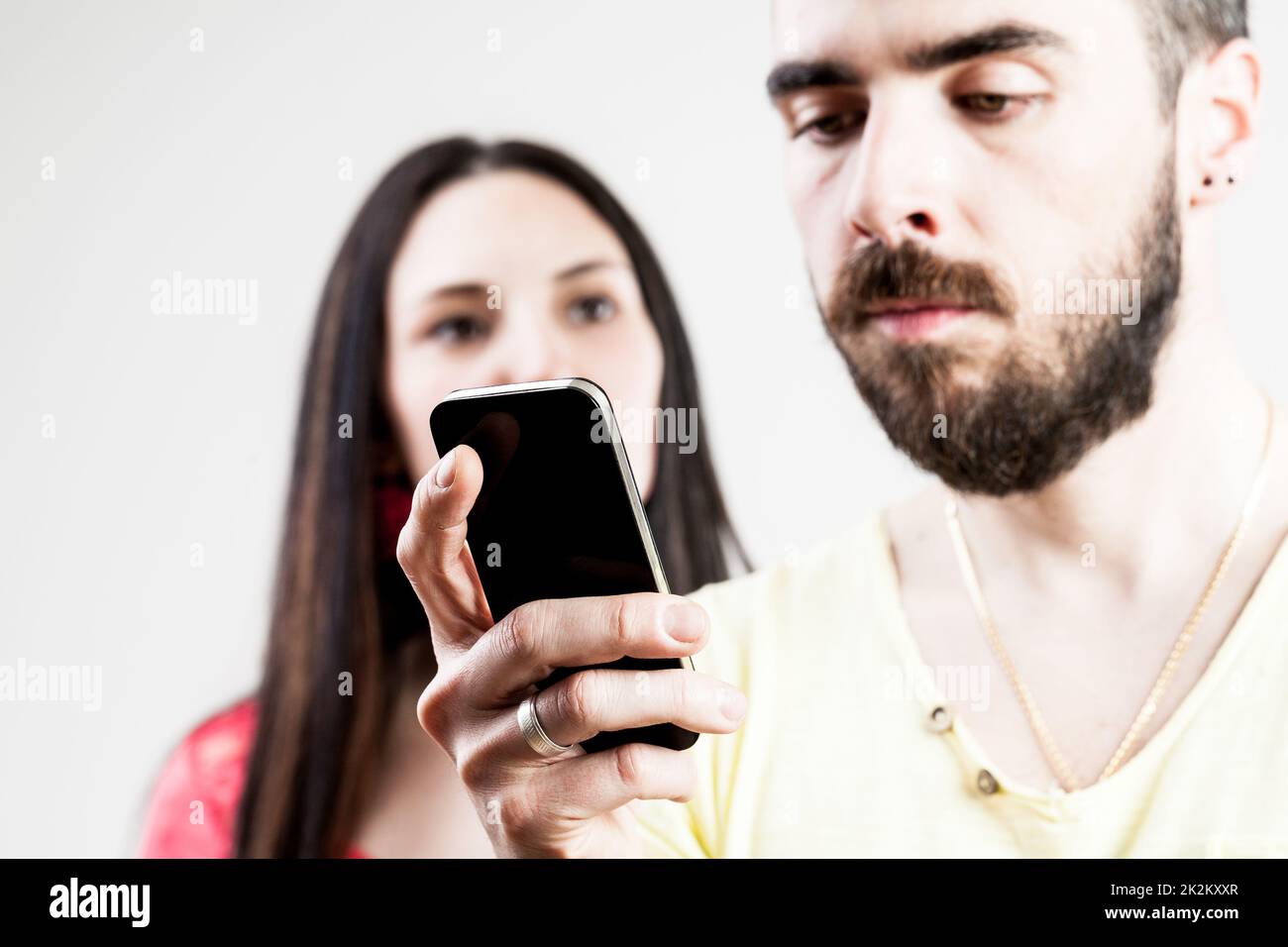 donna delusa per il suo uomo sul suo cellulare Foto Stock